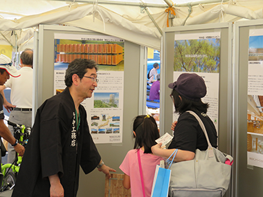 展示パネルの説明を聞く親子連れ